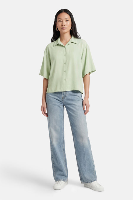 Chemise vert clair de AMELIE ET AMELIE, portée avec un jean bleu et des baskets blanches.