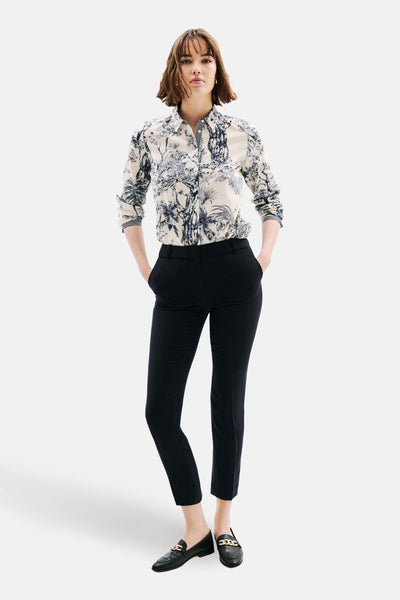 Chemise à manches longues multicolore de CAROLL, avec un motif floral et végétal, portée avec un pantalon noir et des mocassins.
