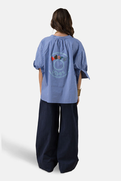 Blauw gestreept overhemd met lange mouwen van ADORE, met geborduurd patroon op de rug, gedragen met een marineblauwe wijde broek.
