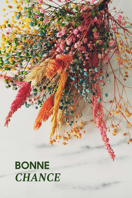 PointCarré "Veel Succes" Cadeaubon, met een boeket kleurrijke gedroogde bloemen op een gemarmerde achtergrond.