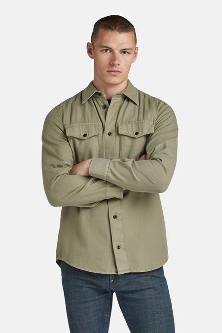 Chemise à manches longues verte de G-Star RAW, avec poches boutonnées sur la poitrine, portée avec un jean bleu.