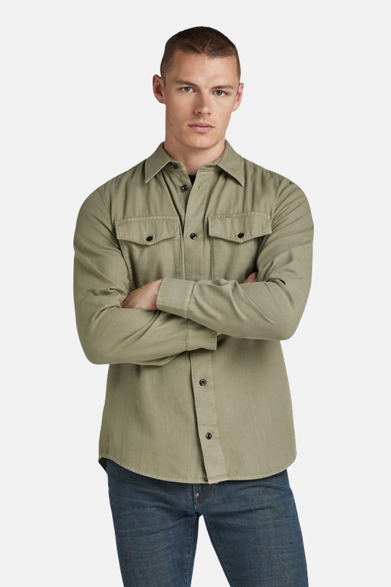 Chemise à manches longues verte de G-Star RAW, avec poches boutonnées sur la poitrine, portée avec un jean bleu.
