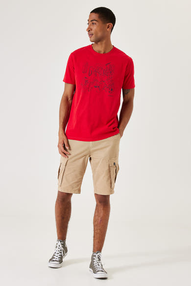 Beige bermuda van GARCIA, met cargozakken en gedragen met een rood T-shirt en hoge sneakers.