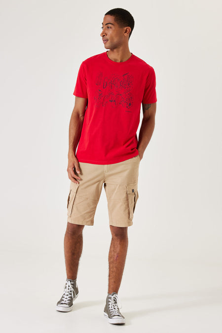 Beige bermuda van GARCIA, met cargozakken en gedragen met een rood T-shirt en hoge sneakers.