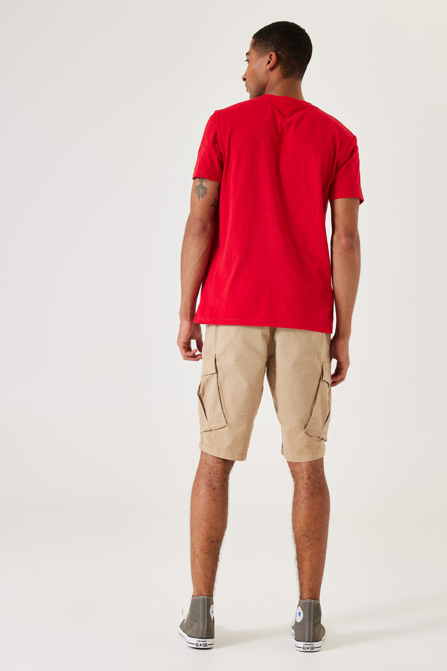 Beige bermuda van GARCIA, met cargozakken en gedragen met een rood T-shirt en hoge sneakers.