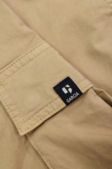 Bermuda beige van GARCIA, détail poche cargo avec étiquette logo de la marque.
