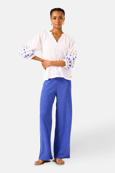 Wit overhemd met lange mouwen van GARCIA, versierd met blauwe borduursels, gedragen met een geplooide blauwe broek.