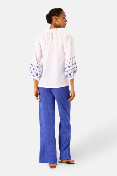 Wit overhemd met lange mouwen van GARCIA met blauwe borduursels op de mouwen, gedragen met een blauwe broek.