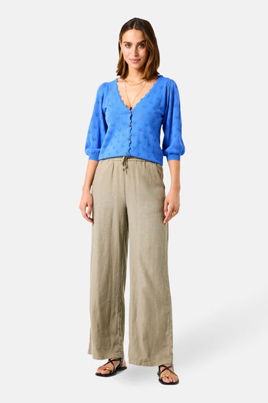 Blauwe GARCIA-cardigan met een ajourpatroon, gedragen met een wijde linnen broek en sandalen met bandjes.