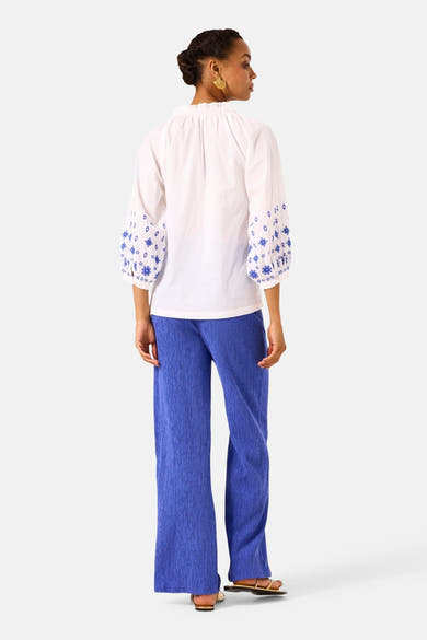 Blauwe textuur broek van GARCIA, wijd en recht model, gedragen met een geborduurd wit hemd.