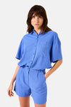 Short bleu de GARCIA, avec une taille haute et des plis, porté avec une chemise assortie.