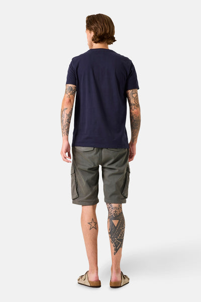 T-shirt bleu marine à manches courtes de GARCIA, porté avec un short cargo kaki et des sandales beiges.