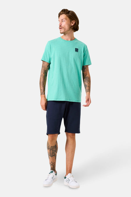 Groen T-shirt met korte mouwen van GARCIA, gedragen met een marineblauwe korte broek en witte sportschoenen.