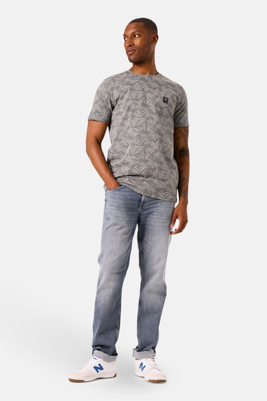T-shirt à manches courtes kaki de GARCIA, avec un motif de feuilles et porté avec un jean bleu.