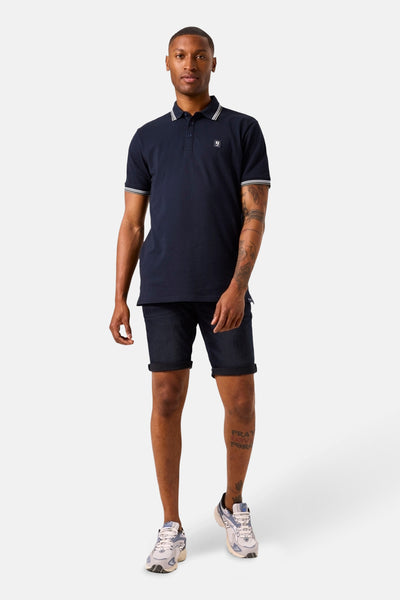 Blauw poloshirt met korte mouwen van GARCIA, met witte strepen op de kraag en mouwen, gedragen met een donkere spijkerbroek.