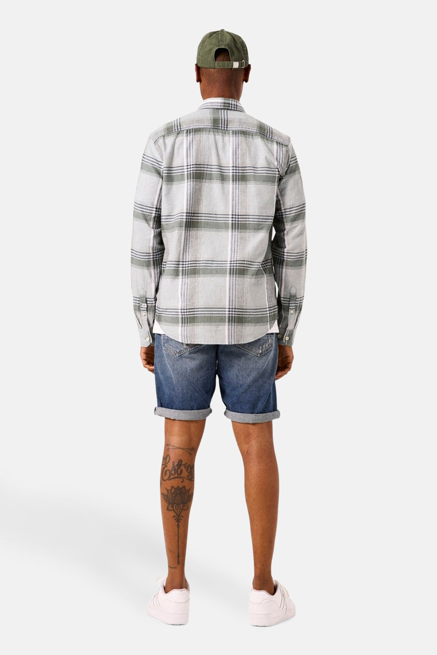 Chemise à manches longues kahki de GARCIA, à carreaux, portée avec un short en jean et une casquette.