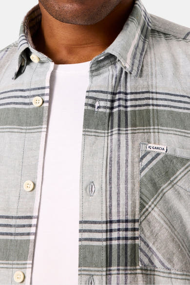Chemise à manches longues kaki par GARCIA, à carreaux avec poche poitrine visible et boutonné sur un t-shirt blanc.