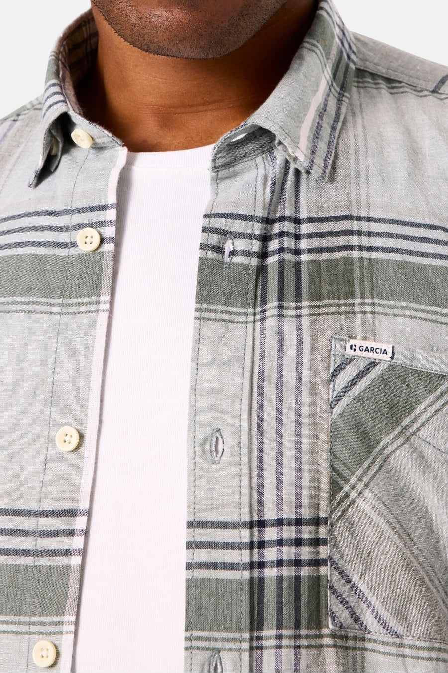 Chemise à manches longues kaki par GARCIA, à carreaux avec poche poitrine visible et boutonné sur un t-shirt blanc.