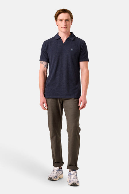 Kaki chino van GARCIA, gedragen met een marineblauw poloshirt en meerkleurige sneakers.