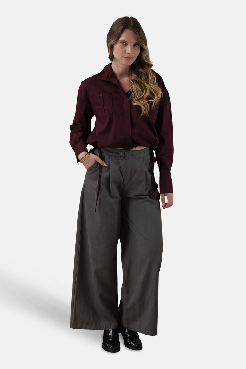 Bordeaux blouse met lange mouwen van ADORE, met borstzakken, gedragen met een grijze broek met hoge taille.