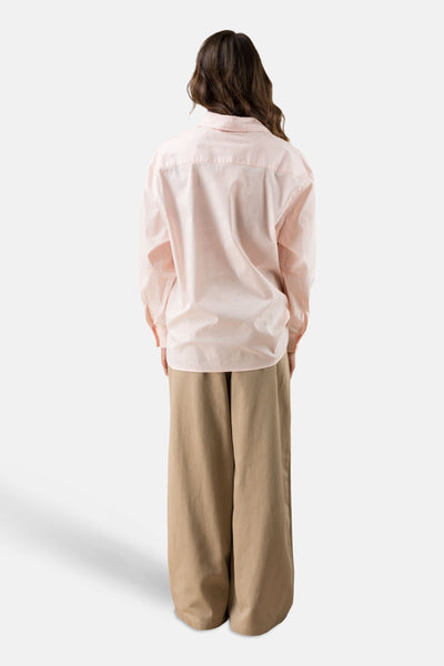 Chemise à manches longues rose de ADORE, vue de dos, portée avec un pantalon beige ample.