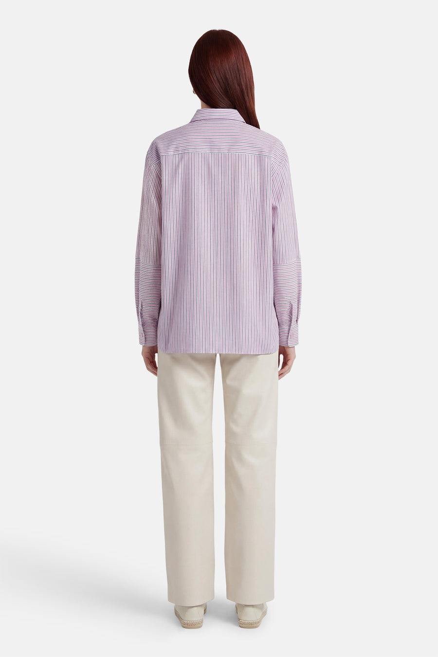 Chemise à rayures rose et blanches de ADORE, manches longues avec poignets boutonnés, portée avec un pantalon écru.