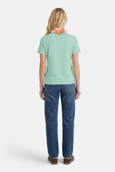 Green short-sleeve t-shirt back view with ribbed texture, worn with blue jeans and a colorful scarf at the neck