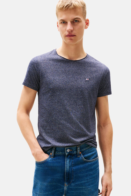 T-shirt bleu à manches courtes de Tommy Jeans, avec un petit logo sur la poitrine, porté avec un jean.
