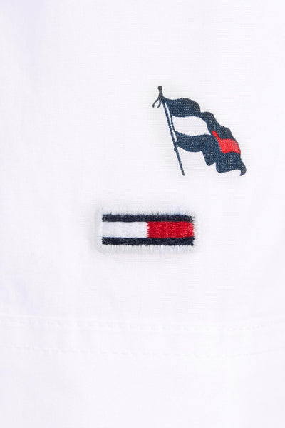 Chemise blanche à manches longues de Tommy Jeans avec logo drapeau brodé et texture subtile.