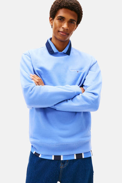 Blauwe sweater van TOMMY JEANS, met een klassieke kraag en een wijde indigo spijkerbroek.