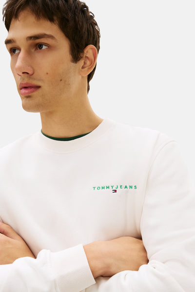 Witte rondehals sweatshirt van TOMMY JEANS met geborduurd logo op de borst en groene binnenkant van de kraag.