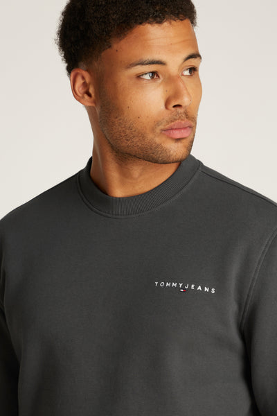 Zwarte rondehals sweatshirt van TOMMY JEANS, met het geborduurde merklogo op de borst.