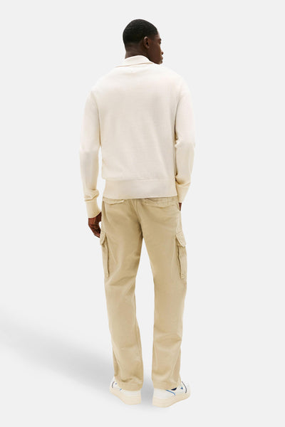 Pull beige de TOMMY JEANS, porté avec un pantalon cargo en velours côtelé et des baskets blanches, vue de dos.