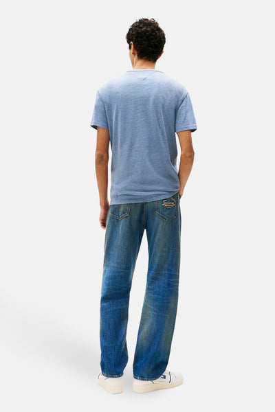 Blauw T-shirt met korte mouwen van TOMMY JEANS, gedragen met een spijkerbroek en witte sneakers, achterzicht.