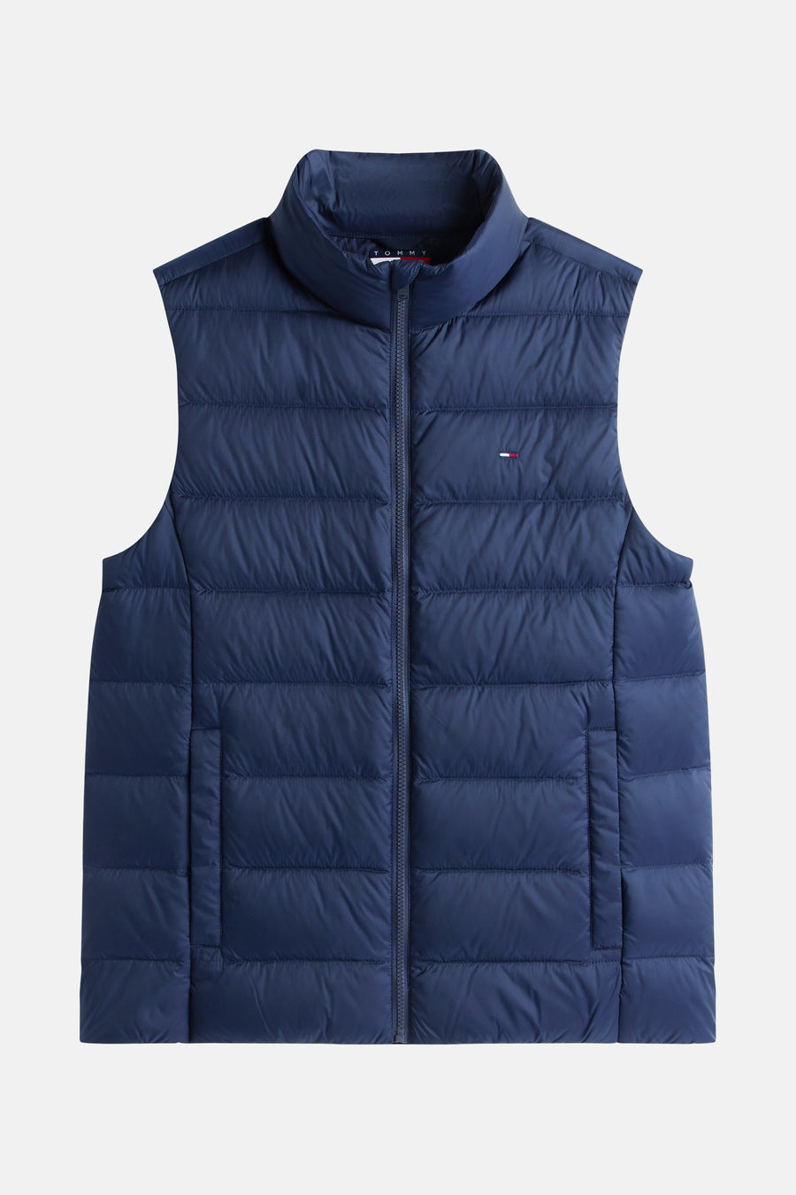 Blauwe mouwloze jas van TOMMY JEANS, met ritssluiting en discreet logo op de borst.