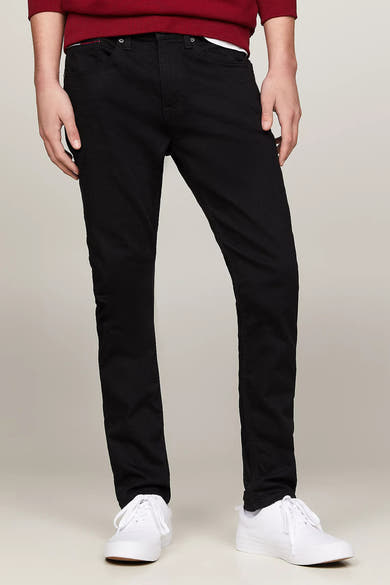 Jean noir en denim AUSTIN de TOMMY JEANS, porté avec un pull bordeaux et des chaussures blanches.
