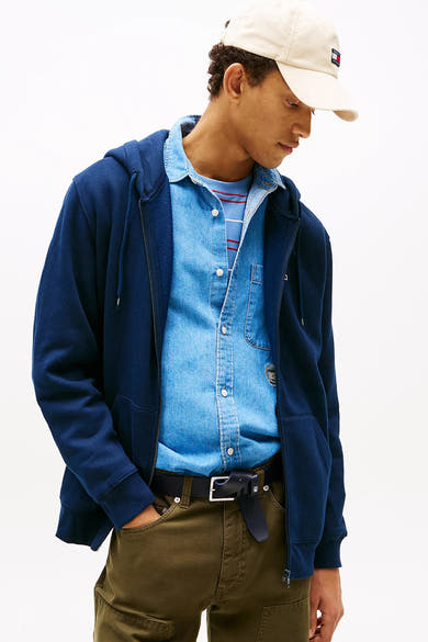 Gilet bleu de Tommy Jeans porté avec une chemise en jean et un pantalon cargo olive.