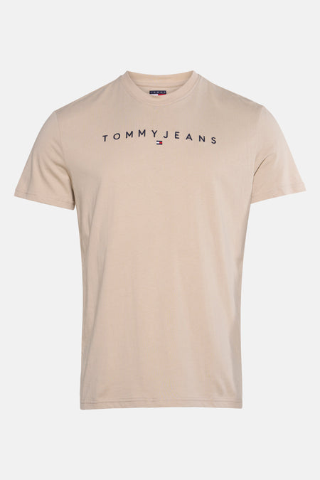 Beige T-shirt met korte mouwen van TOMMY JEANS met het merklogo op de voorkant gedrukt.