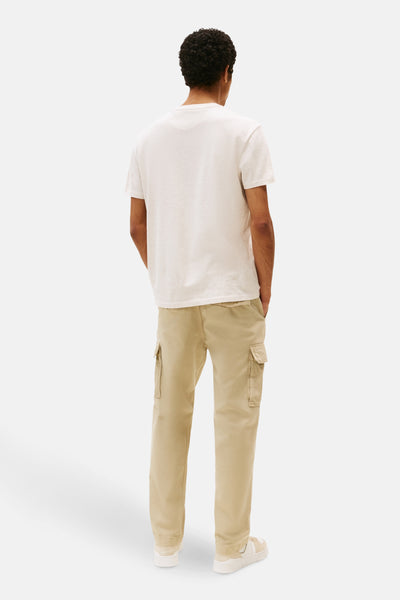 Beige T-shirt met korte mouwen van TOMMY JEANS, gedragen met een cargobroek en sneakers.