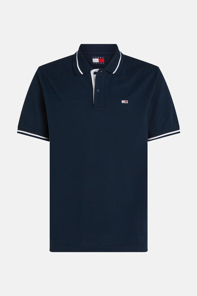 Blauw poloshirt met korte mouwen van TOMMY JEANS met witte strepenafwerking aan de kraag en mouwen.