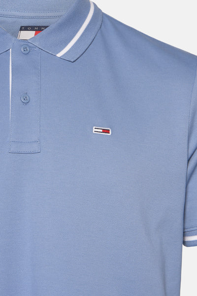 Polo bleu en maille piquée de TOMMY JEANS, avec rayures blanches au col et logo distinctif.