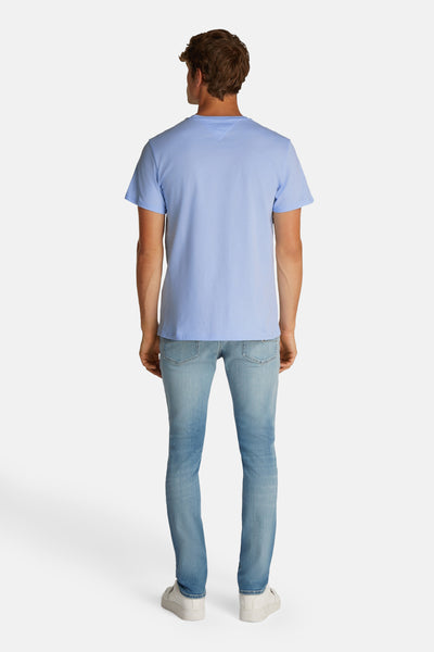 Blauw T-shirt met korte mouwen van TOMMY JEANS, gedragen met een lichtblauwe jeans en witte sneakers, achterzijde.