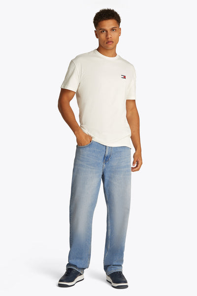Rechte lichtblauwe denim jeans van TOMMY JEANS, gedragen met een wit T-shirt en marineblauwe schoenen.