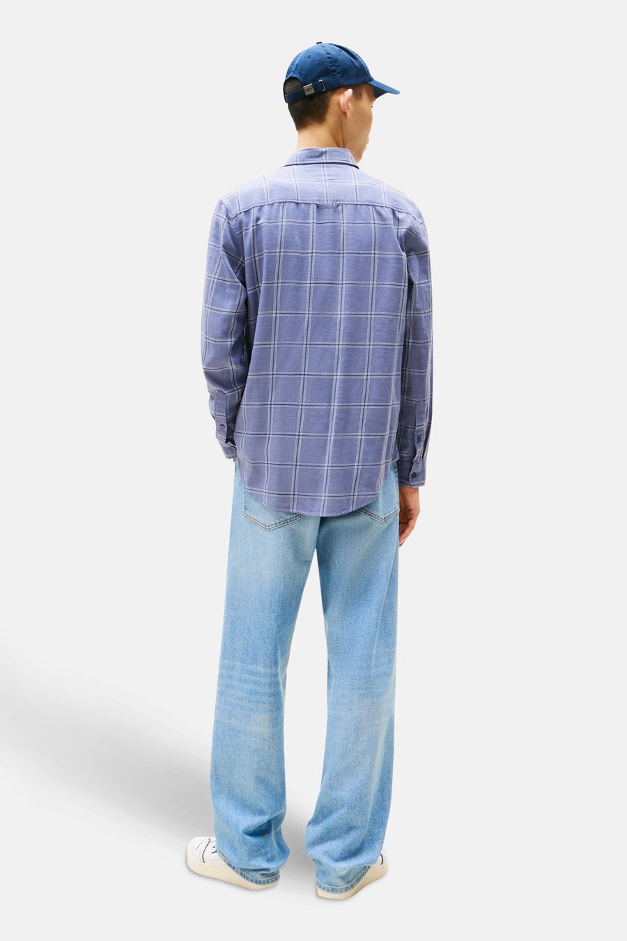 Chemise à manches longues bleue à carreaux de TOMMY JEANS, portée avec un jean délavé et une casquette bleue