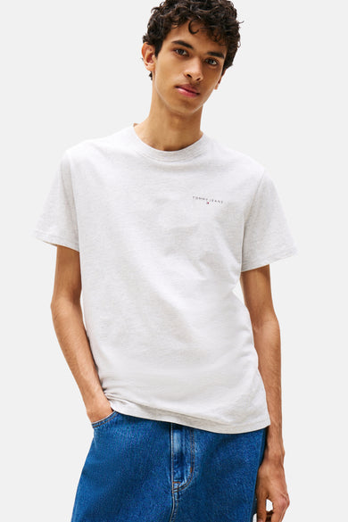 Grijze gemêleerde T-shirt met korte mouwen van TOMMY JEANS, gedragen met een effen blauwe jeans.