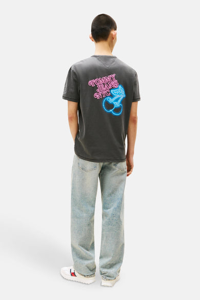 Grijze T-shirt met korte mouwen van TOMMY JEANS, met kersenprint en belettering op de rug, gedragen met een blauwe jeans.