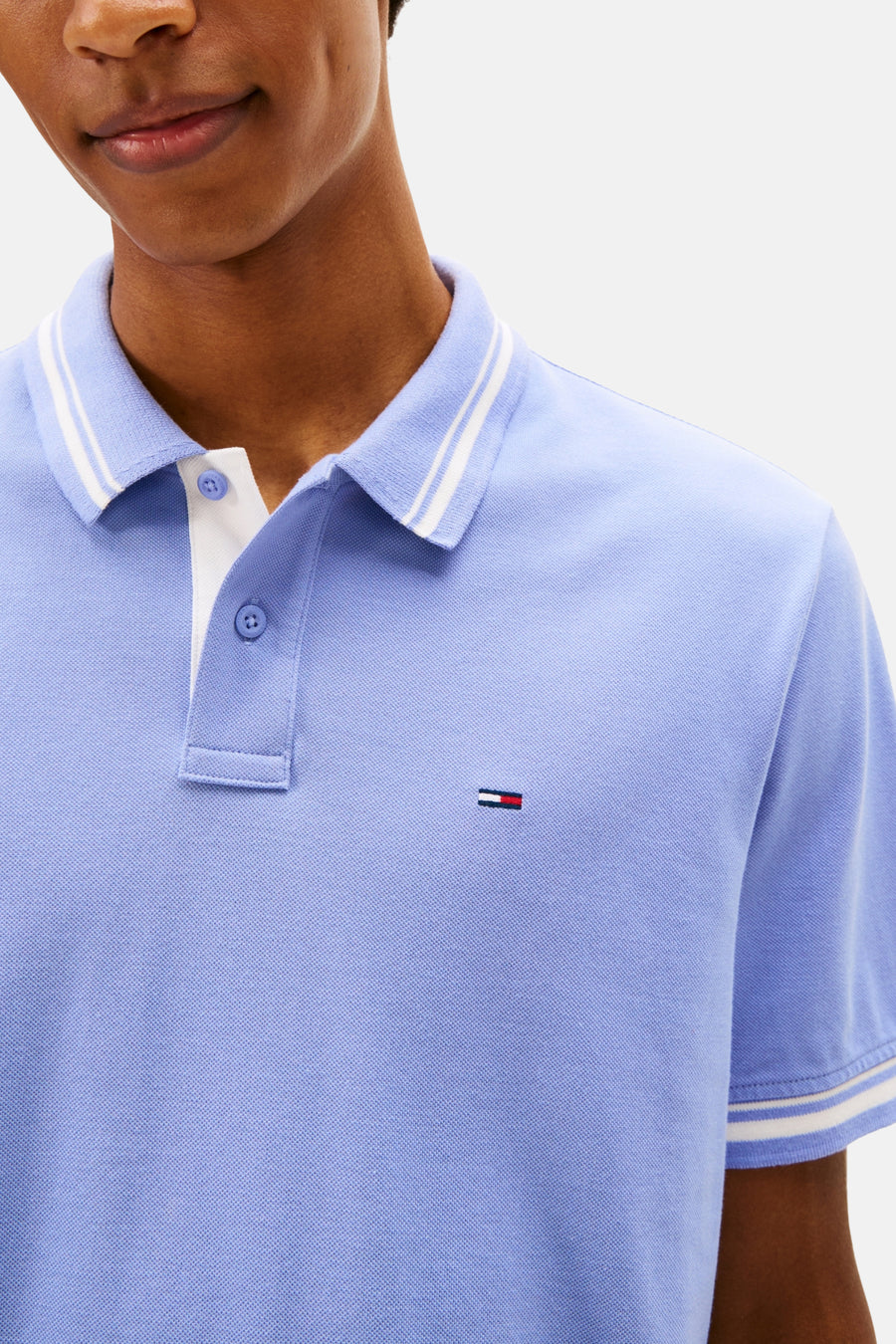 Polo mauve à manches courtes de TOMMY JEANS, col rayé blanc et détail du logo subtil.