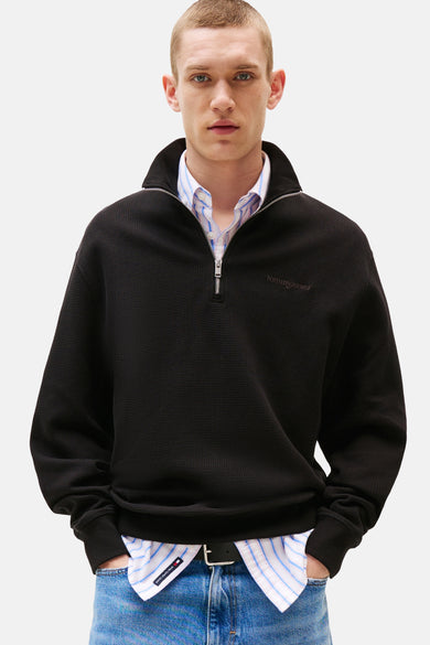 Sweat noir à col montant par Tommy Jeans, avec texture gaufrée et fermeture éclair partielle.