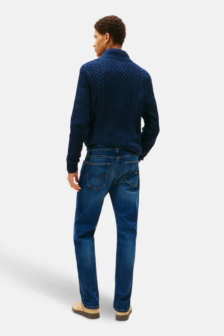 Rechte donkerblauwe denim jeans van TOMMY JEANS, klassieke pasvorm, gedragen met een kabelgebreide trui.
