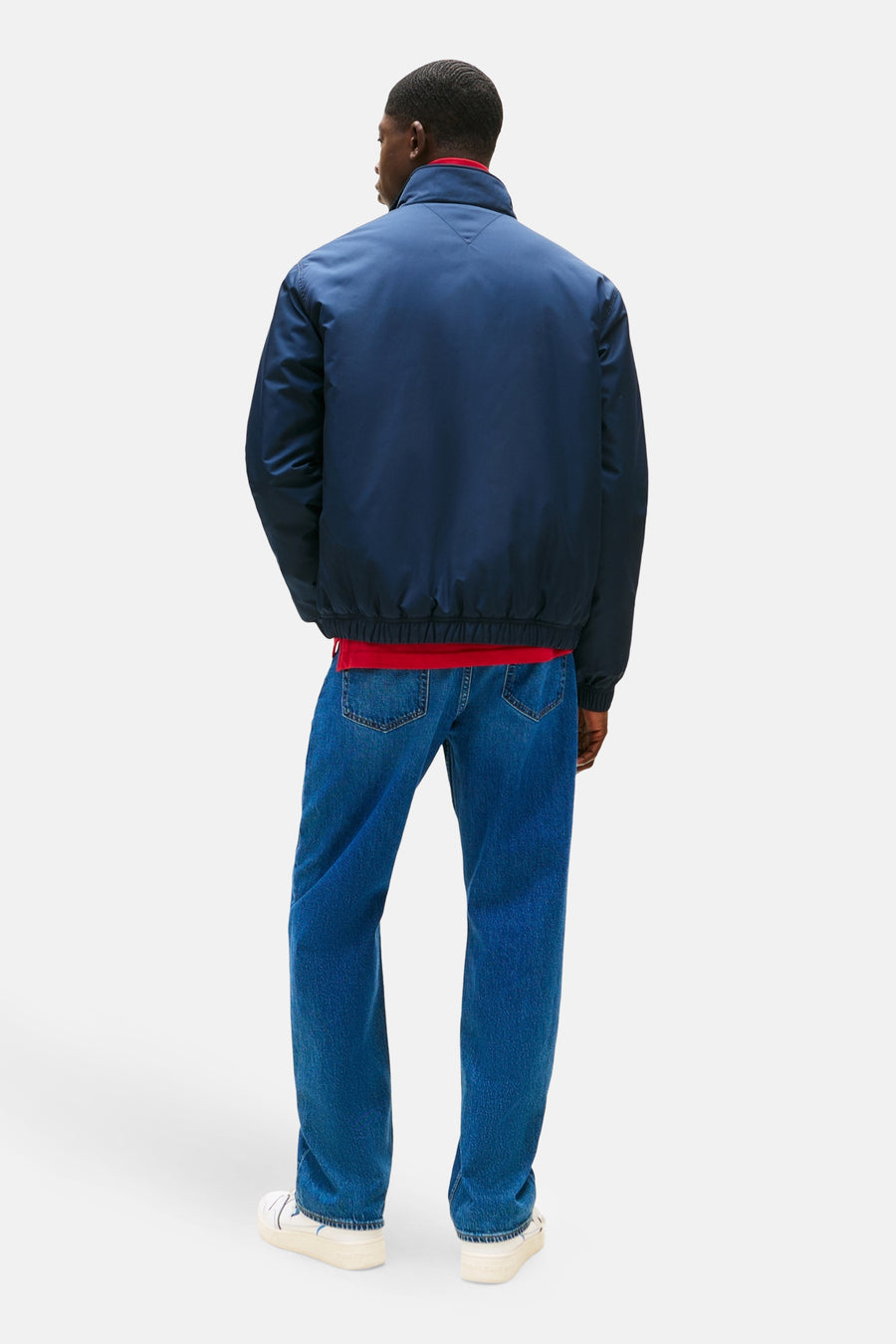Imperméable bleu de TOMMY JEANS, porté avec un t-shirt rouge et un jean bleu, vue arrière.